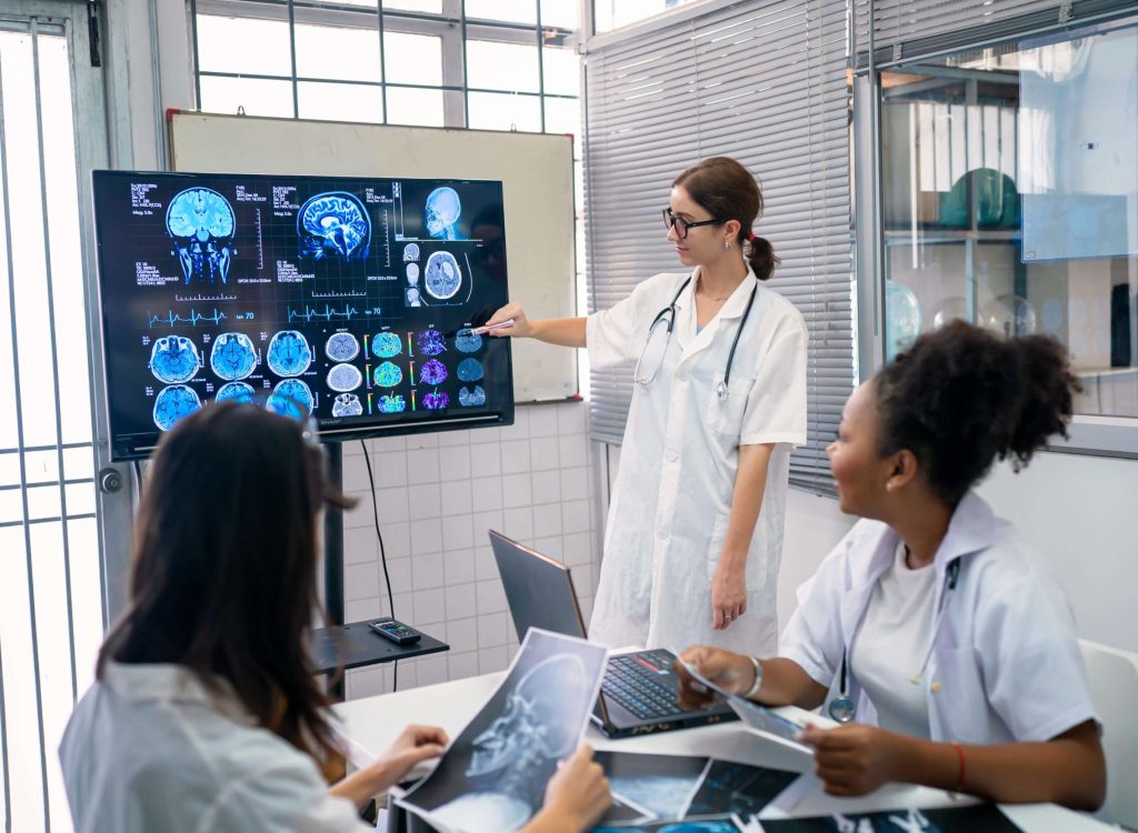 Team of doctors discuss results of X-Ray or MRI scan of patient's brain in medicine office of clinic